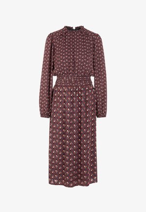 Long-sleeve dress in dark burgundy with a geometric diamond pattern in red and beige. Features a smocked waist and high neck.