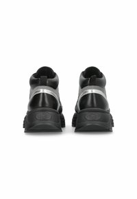 Chaussures noires avec une tige texturée, dotées d'une bande réfléchissante argentée, d'une semelle rembourrée et d'une languette à l'arrière pour un enfilage facile.