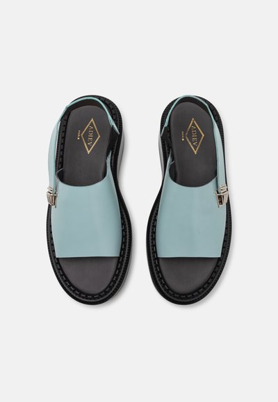 To par åbne sandaler med en lyseblå overdel og sort gummisål. Har en slingback-strop med sølvhardware og en glat tekstur.