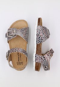 Sandales argentées et rouges à motifs avec deux brides, boucle ajustable et semelle en liège. Semelle en caoutchouc blanc avec un relief texturé.