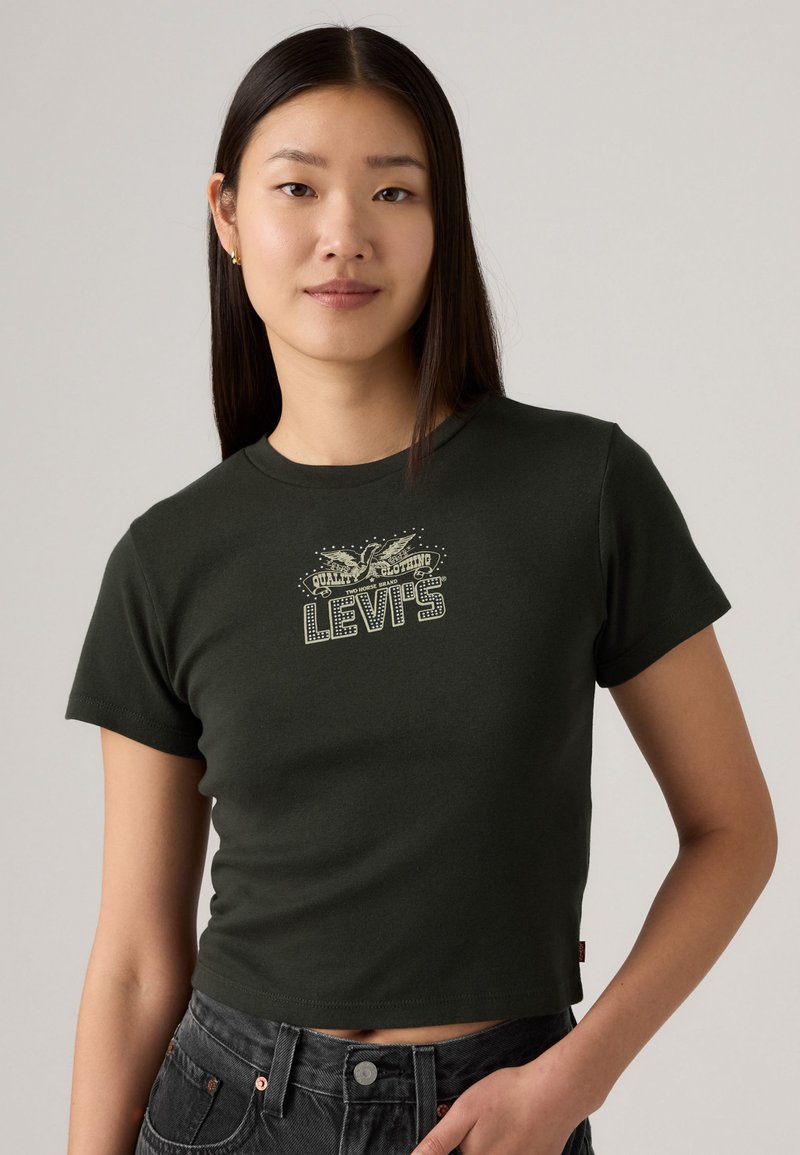 T-shirt en coton vert foncé avec un col rond, des manches courtes et un imprimé graphique avec "Levi's" dans un style rétro sur le devant.