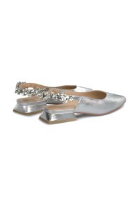 Ballerine metalliche argento con tacco basso a blocco, caratterizzate da una fascia adornata di gemme sul retro e un materiale superiore dalla texture liscia.