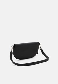 Černá kabelka vyrobená z texturovaného syntetického materiálu, s zakřiveným tvarem, prošíváním a nastavitelným popruhem.