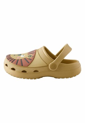 Vaaleanruskea kuminen puukenkä, jossa säädettävä kantaremmi ja leikkisä leijonan kasvojen kuvio varren kohdalla.