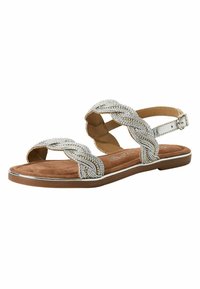 Sandales plates à lanières avec des brides en argent tressées, semelle intérieure rembourrée beige et semelle extérieure marron. Fermeture à boucle à la cheville.