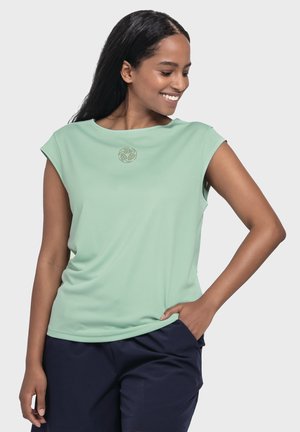 Light green short-sleeve top with a crew neckline, made of soft fabric, featuring a subtle logo on the front. Worn with dark shorts.