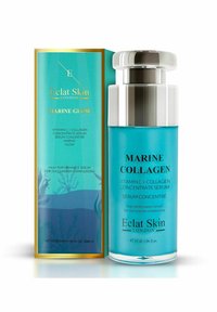 Serum kolagenowy z morszczynów w przezroczystej butelce z metalową srebrną nakrętką, zawierający turkusowy płyn. Towarzyszy mu jasnoniebieskie pudełko ze złotymi akcentami.
