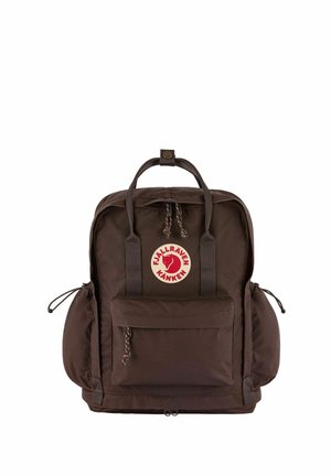 Bruine Fjällräven Kånken rugzak met voorvak met ritssluiting, twee zijzakken, bovenhandvatten en een ronde rode logopatch aan de voorkant.