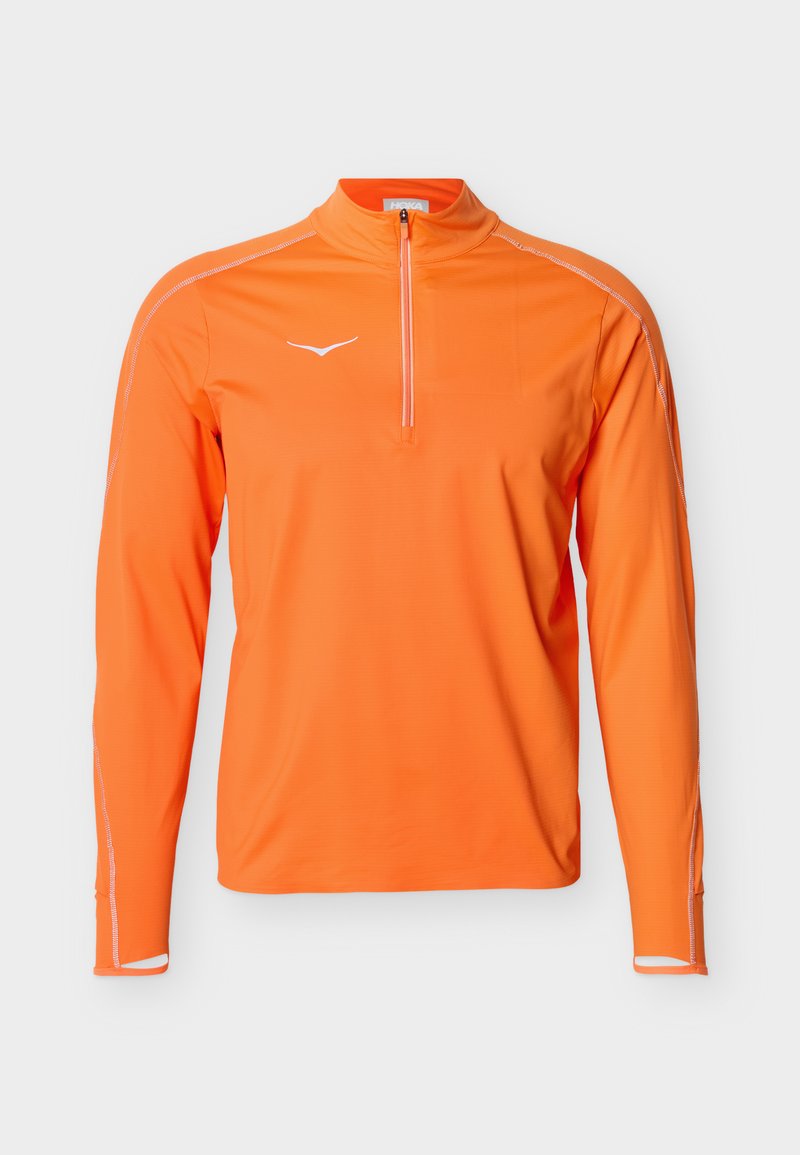 Leuchtend orangefarbenes, langärmeliges Sportoberteil mit Viertelreißverschluss, Daumenlöchern, weißem Logo auf der Brust und weißen Nähten entlang der Ärmel.