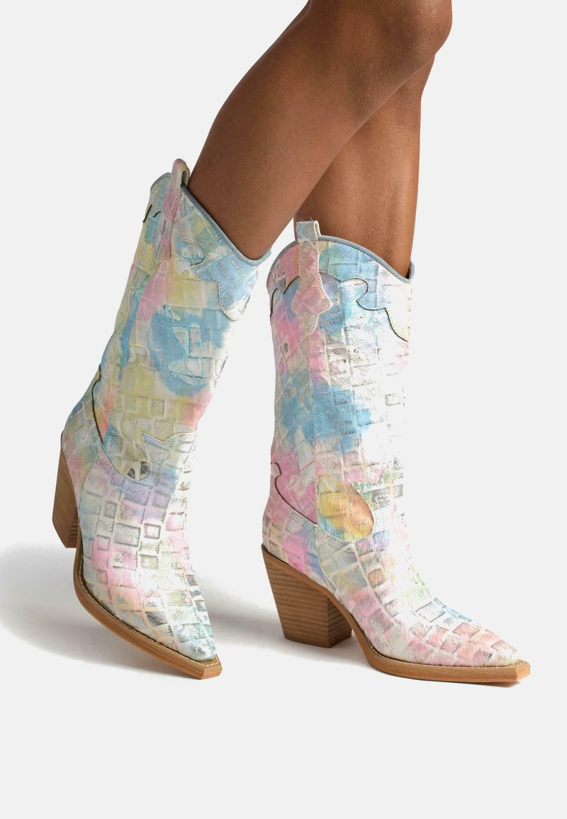 Bottes de cowboy colorées et à motifs avec une finition brillante, présentant des tons de bleu clair, rose et blanc, un bout pointu et un talon en bois empilé.