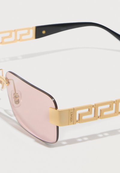 Γυαλιά ηλίου με ροζ ορθογώνιους φακούς, χρυσούς βραχίονες με σχέδιο ελληνικού κλειδιού και την επιγραφή "VERSACE" στον μεντεσέ.