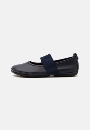 Chaussure plate en cuir bleu marine avec bout arrondi et large bride élastique sur le dessus, présentée de profil sur un fond clair.