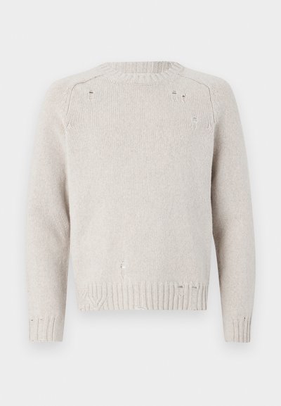 Hellbeige gestrickter Pullover mit rundem Ausschnitt, langen Ärmeln und abgetragenen Details auf der Vorderseite und am Saum. Strukturierte Rippbündchen.