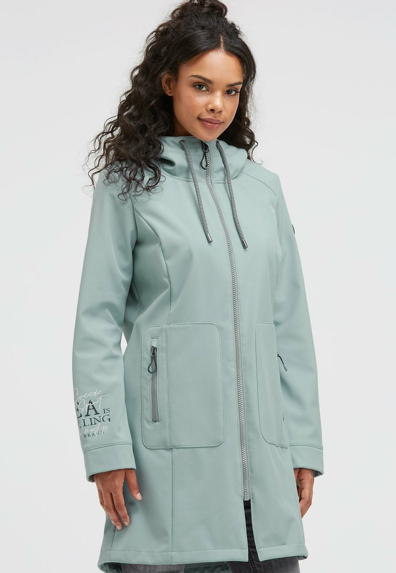 Light green waterproof jacket with a front zipper, adjustable hood, and two side pockets. Features graphical text on the left sleeve.