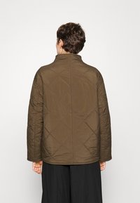 Hnědá prošívaná bunda s vysokým límcem a diamantovým vzorem, s dlouhými rukávy a rovný střih, viděná zezadu.