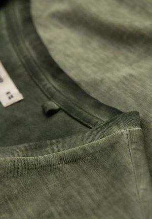 Olivenfarbener T-Shirt-Stoff mit glatter Textur, ausgestattet mit einem Rundhalsausschnitt und genähtem Saum, der dezente Farbvariationen zeigt.