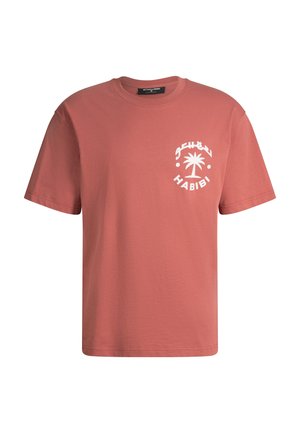 T-shirt manches courtes couleur rouille avec un motif de palmier blanc et l'inscription « Habibi » sur le côté gauche de la poitrine, col rond et coupe régulière.