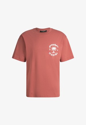 T-shirt manches courtes couleur rouille avec un motif de palmier blanc et l'inscription « Habibi » sur le côté gauche de la poitrine, col rond et coupe régulière.