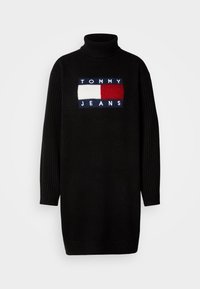 Musta pooloneule, jossa on resorit hihansuissa ja etupuolella sininen, punainen ja valkoinen suorakaiteen muotoinen Tommy Jeans -logo.