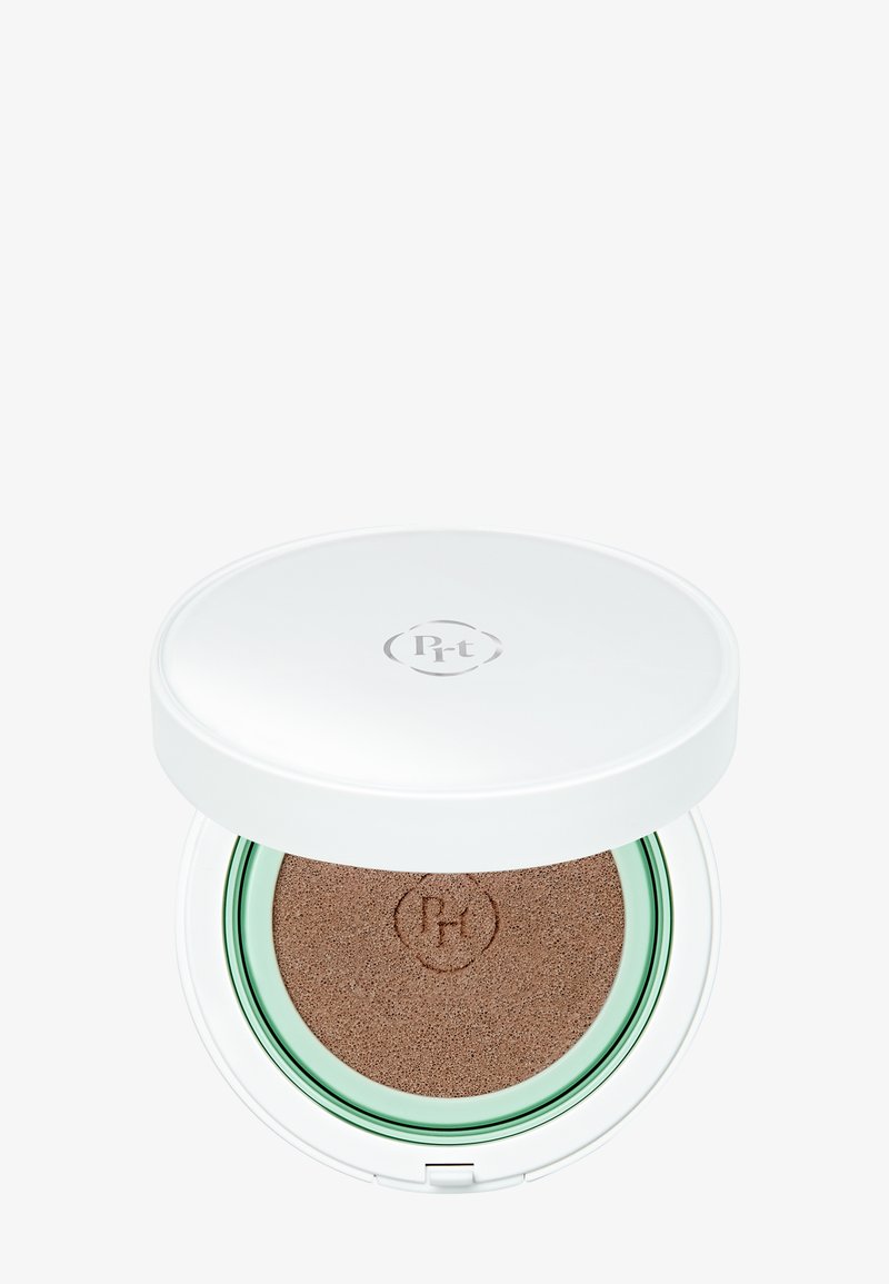 Boîtier de maquillage blanc compact avec fond de teint coussin beige à l'intérieur et logo sur le couvercle ainsi que sur la surface du coussin.