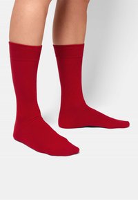 Calze a crew in cotone rosso con polsini a costine, caratterizzate da una texture liscia e un design a tinta unita.