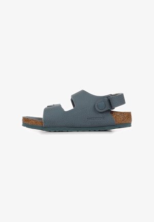 Sandalo Birkenstock in pelle blu texturizzata con sottopiede in sughero, cinturino posteriore regolabile e suola in gomma mostrato di profilo laterale.