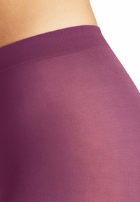 Leggings viola con una texture liscia e elastica e una cintura larga, caratterizzati da una leggera costina per aggiungere dettaglio.