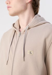 Calvin Klein Jeans LABEL ZIP THROUGH HOODIE - Majica s kapuljačom i patentnim zatvaračem - goat