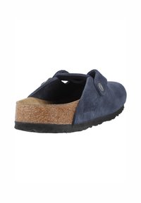Zoccolo in suede blu navy con soletta in sughero e suola in gomma nera; presenta una fibbia sul retro e un dettaglio con bottone in metallo.