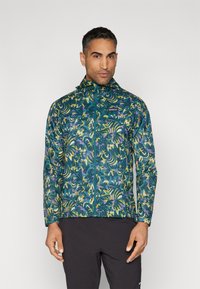 Lett jakke i teal med et abstrakt blomstermønster i gult og lilla. Har full glidelås og justerbar hette.