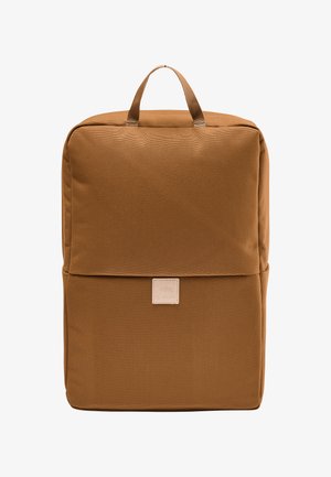 Bruine stoffen rugzak met een rechthoekige vorm, uitgerust met een bovenhandvat en een lichtgekleurde logo-applicatie aan de voorkant. Gladde textuur.