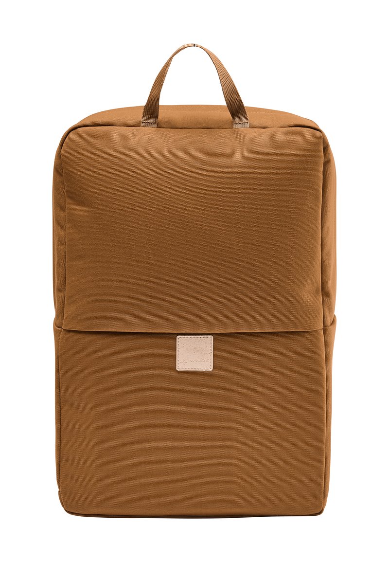 Mochila de tela marrón con forma rectangular, que cuenta con un asa superior y un parche de logo de color claro en la parte frontal. Textura suave.