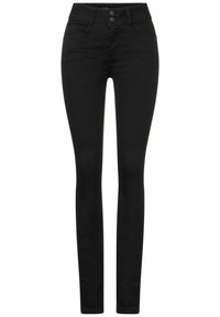 Jeans negros ajustados de mezclilla. Presentan una cintura alta, dos bolsillos frontales y un cierre de doble botón en la cintura. Textura suave.