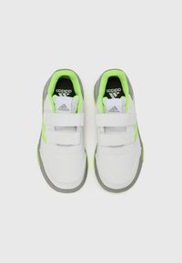 Zapatillas deportivas blancas con acentos grises, detalles en verde neón y correas de velcro. Presentan una suela texturizada y un interior acolchado para mayor comodidad.