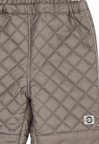 Puffede, grå børnebukser med elastik i taljen, der har et tekstureret diamantmønster og en lille mærkelogo på den nedre del af benet.