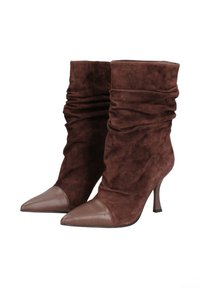 Stivali alla caviglia in suede marrone con un design morbido, punte in pelle a forma appuntita e tacchi sottili. Tessuto testurizzato con dettagli lisci sulla punta.