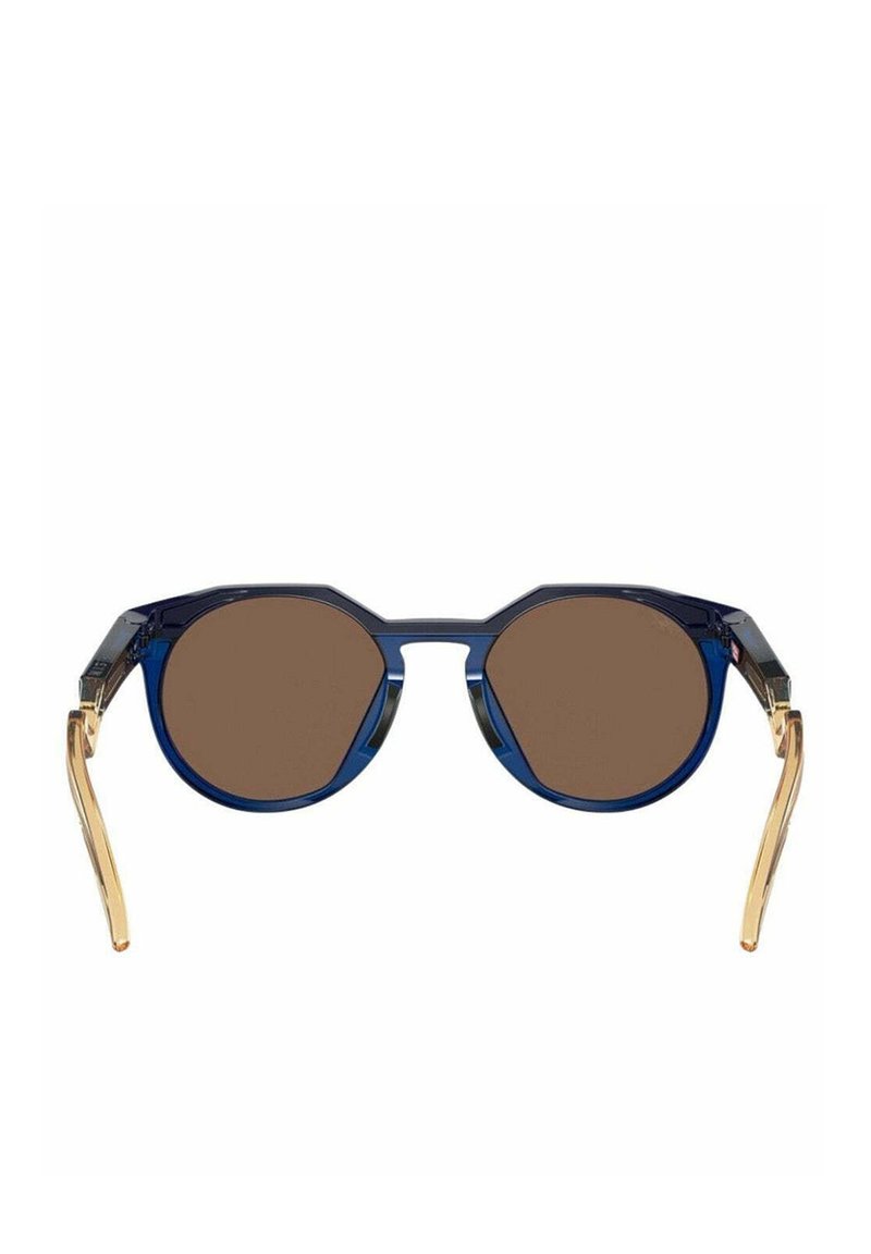 Lunettes de soleil rondes avec monture bleue, verres marron et branches dorées. Présentent un design de verres octogonaux et une texture lisse et brillante.