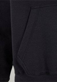 Black sweatshirt fabric featuring a front pouch pocket and ribbed hem. Material has a smooth texture with stitching details.