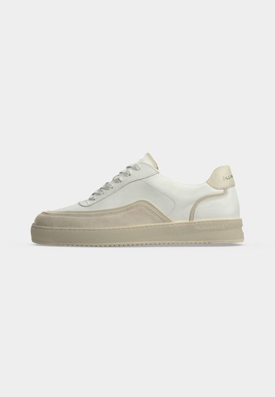 Baskets basses blanches avec détails en daim beige, lacets à l'avant et languette de talon marquée sur un fond clair uni.