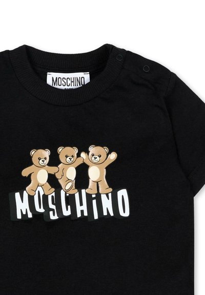 T-shirt bébé noir avec trois ours en peluche ludiques au-dessus du texte blanc "MOSCHINO" et des boutons-pression sur l'épaule pour un enfilage facile.