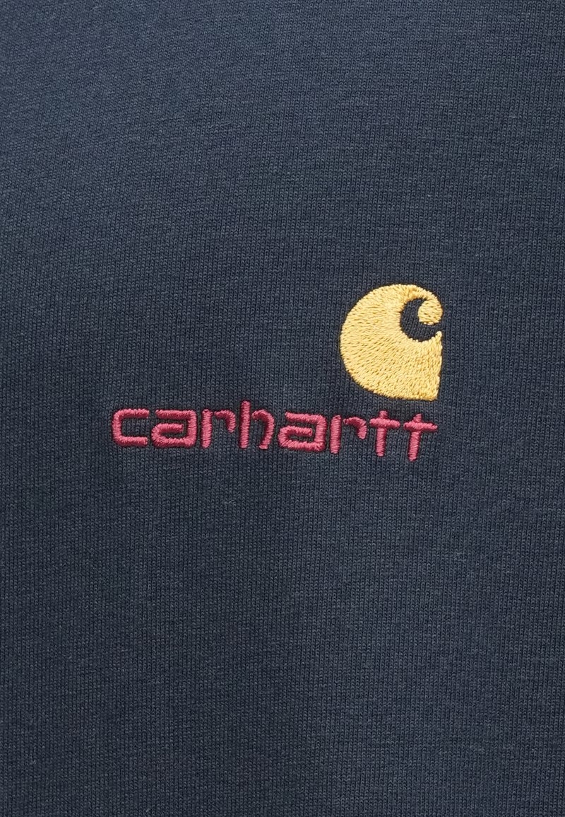 Navy cotton t-shirt featuring a yellow embroidered logo and pink brand name "carhartt" on the front. Smooth texture with a classic fit.