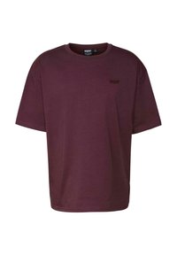 Burgundy színű pamut póló rövid ujjakkal, kerek nyakkal és egy kis hímzett logóval a bal felső oldalon. Sima textúra.