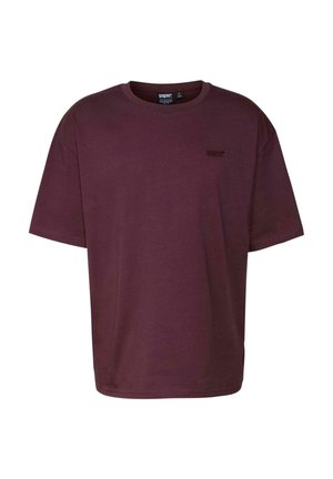 Burgundy színű pamut póló rövid ujjakkal, kerek nyakkal és egy kis hímzett logóval a bal felső oldalon. Sima textúra.