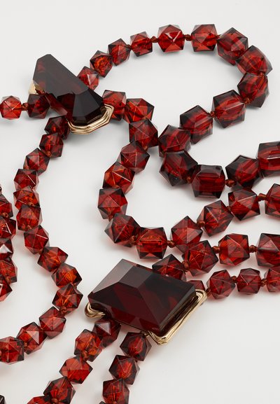 Collana geometrica rossa in cristallo con perline esagonali e chiusura in oro, caratterizzata da forme diverse e una finitura lucida.