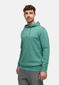 Turkis hoodie laget av teksturert stoff, med snøring i hetta og en horisontal søm over brystet. Slim-fit design.