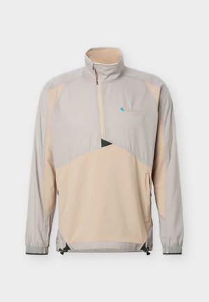 Μπεζ και ανοιχτό γκρι μακρυμάνικο πουλόβερ με μπροστινό φερμουάρ μέχρι τη μέση, ψηλό γιακά, ελαστικές μανσέτες και πλευρικές τσέπες με φερμουάρ.