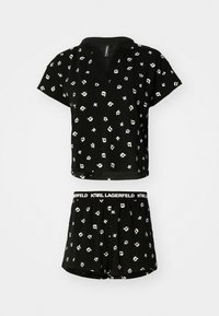 Schwarzes Kurzarm-Oberteil und Shorts-Set mit einem sich wiederholenden Muster aus cartoonartigen Gesichtern. Hergestellt aus weichem Stoff, mit einem elastischen Bund.