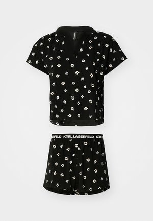 Melns īsām piedurknēm tops un šortu komplekts ar atkārtojošos zīmējumu ar multfilmu stila sejas. Izgatavots no mīksta auduma, ar elastīgu jostasvietu.