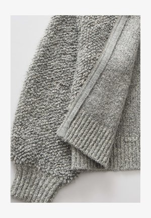 Grijze zip-up sweater met een textuur van zachte stof en ribgebreide manchetten en zoom. De rits is opvallend aan één kant voor het sluiten.