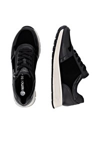 Schwarze Sneakers aus verschiedenen Materialien, mit einem glatten Lederobermaterial und strukturierten Akzenten, Schnürverschluss und einer weißen Gummisohle.